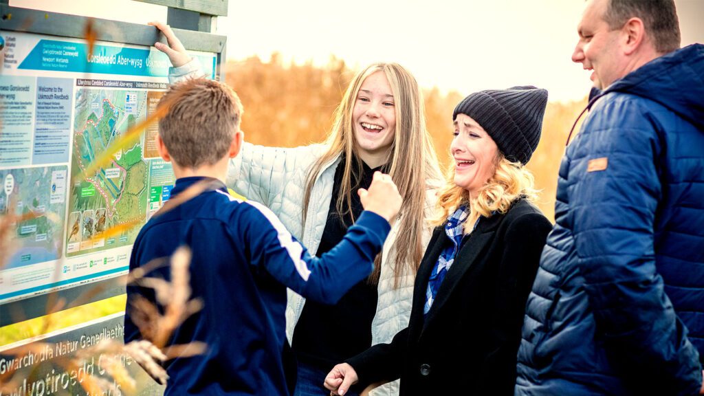 foster family smiling pointing at a trail map