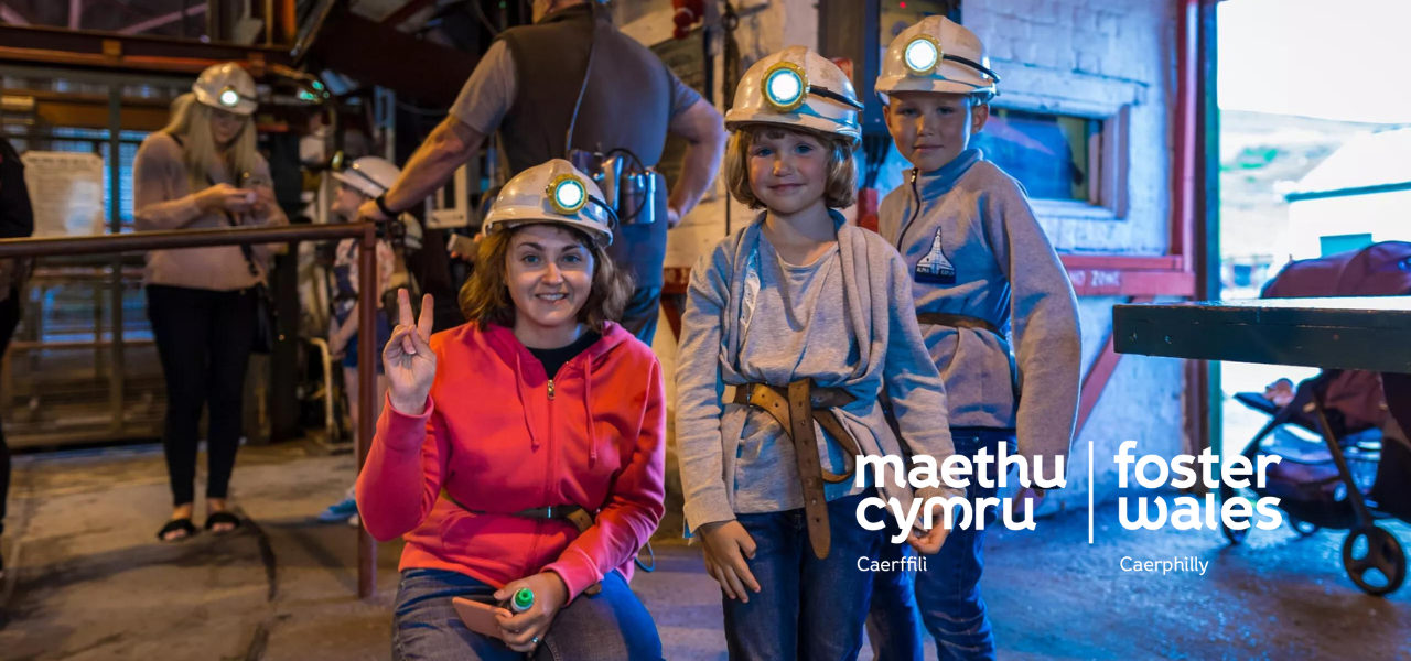 Foster Wales Woman and two children with mining gear equipped smiling