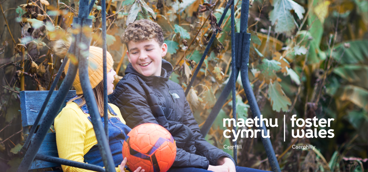 Foster Wales two children boy and girl smiling on garden swing with football
