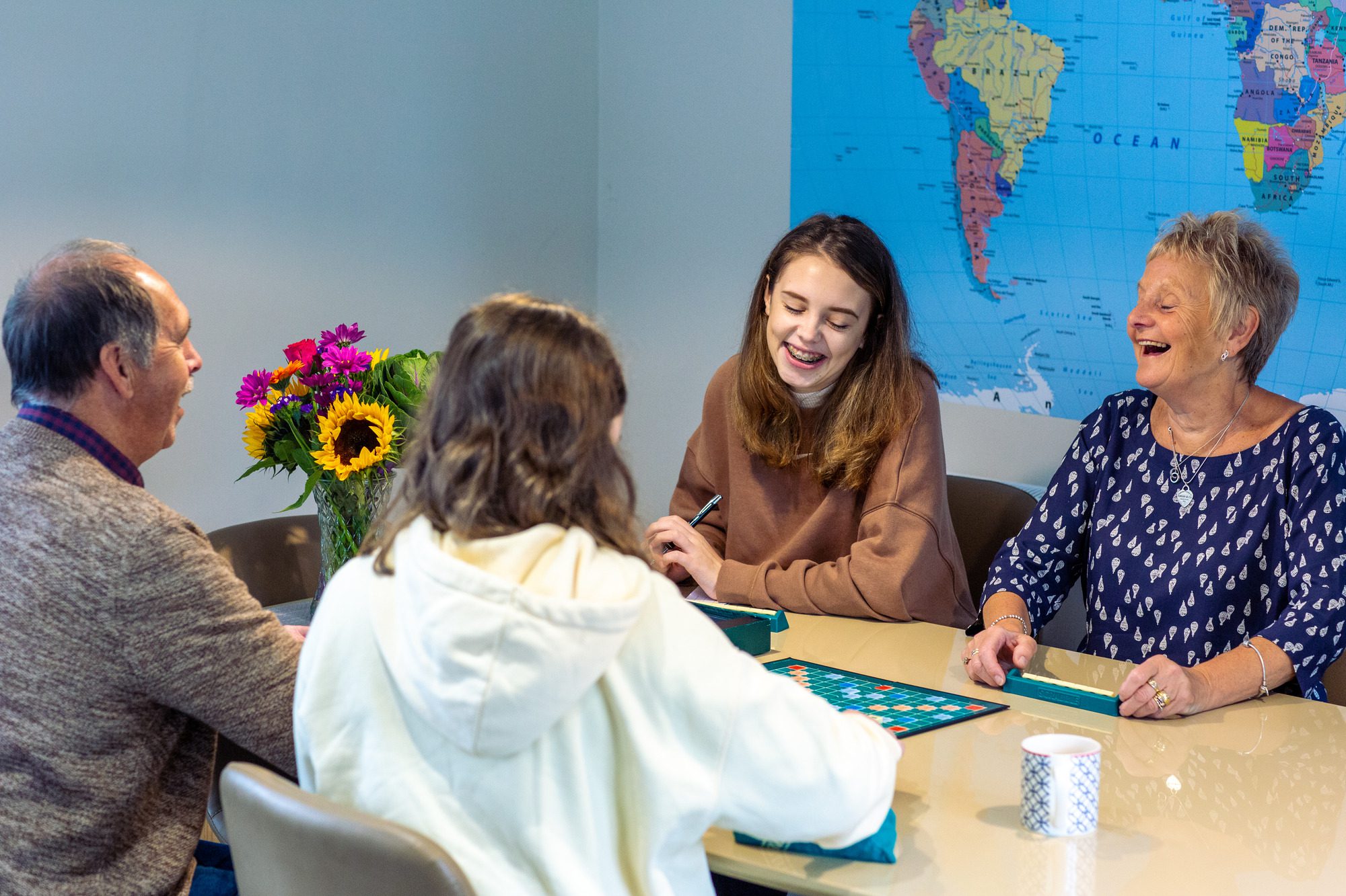 family laughing around the dinner table playing board games