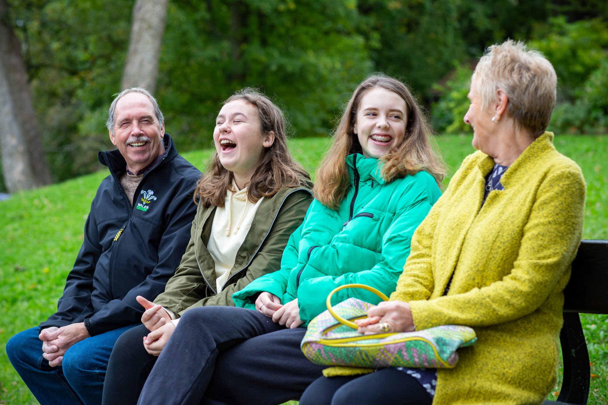 Family sitting on park bench